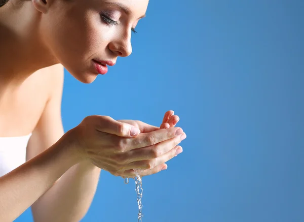 Giovane femmina lavarsi il viso con acqua limpida — Foto Stock