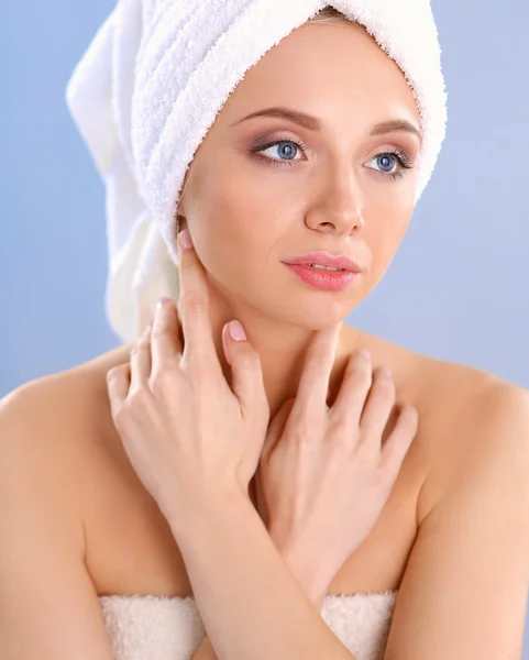 Beautiful woman with a towel on her head on a gray background — Stock Photo, Image
