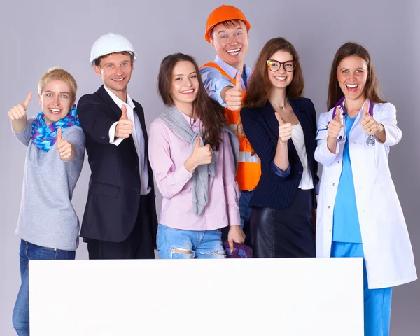 Retrato de personas sonrientes con varias ocupaciones sosteniendo cartelera en blanco mostrando ok —  Fotos de Stock