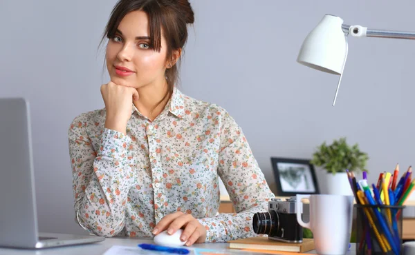 Porträtt av ung kvinna sitter vid skrivbord — Stockfoto