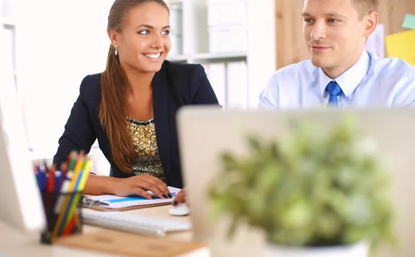 Fashion designers working in studio sitting on the desk — Stock Photo, Image