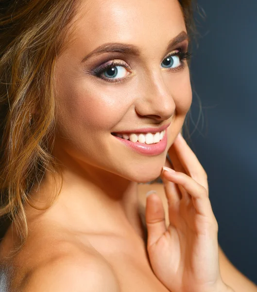 Schöne Frau mit lockigen langen Haaren auf dunklem Hintergrund — Stockfoto