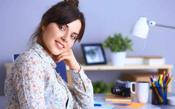 Retrato de una joven sentada en el escritorio — Foto de Stock