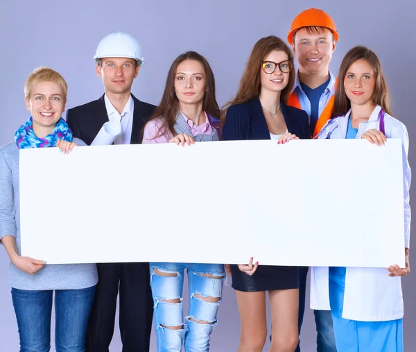 Portret van lachende mensen met verschillende beroepen die blanco reclamebord houden — Stockfoto