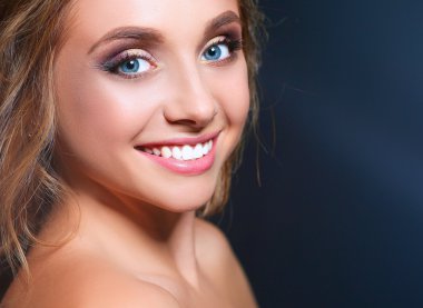 Koyu arka plan üzerinde kıvırcık uzun saçlı güzel kadın