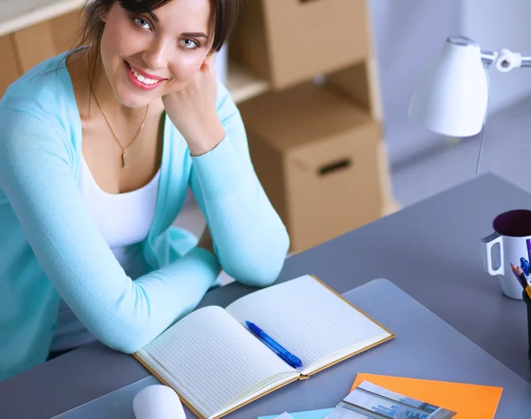 Retrato de una joven sentada en el escritorio — Foto de Stock