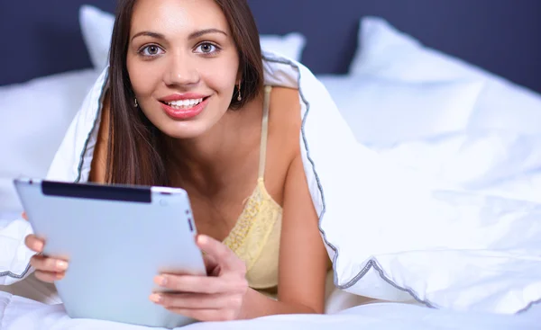 Vrouwen gebruiken een tablet pc op het bed — Stockfoto