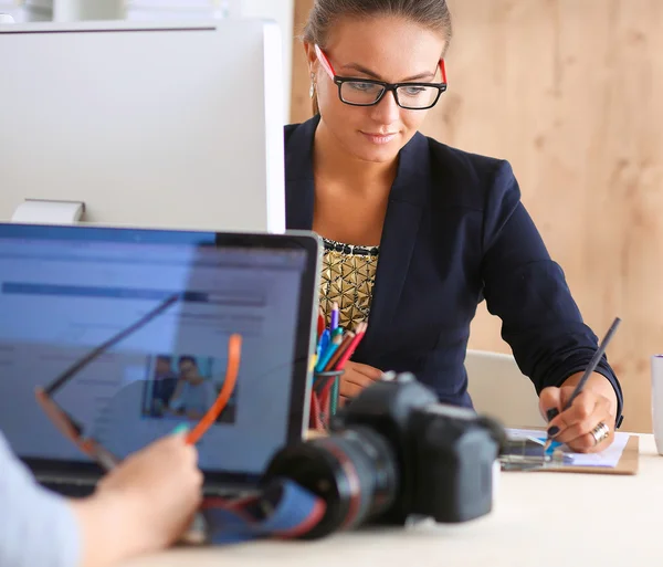 Modedesigner, die im Atelier arbeiten, sitzen am Schreibtisch — Stockfoto