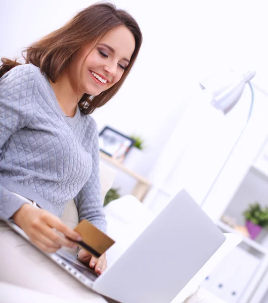 Bella donna sorridente con computer portatile e una carta di credito — Foto Stock