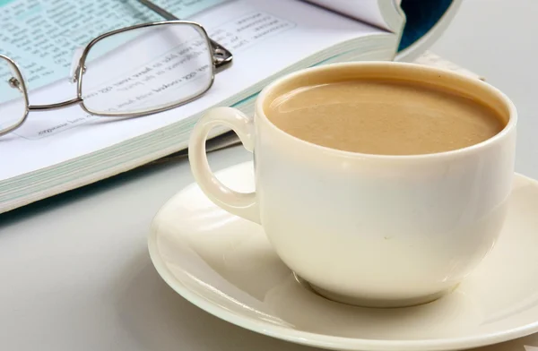 Cup of coffee near the laptop and newspapers — Stock Photo, Image