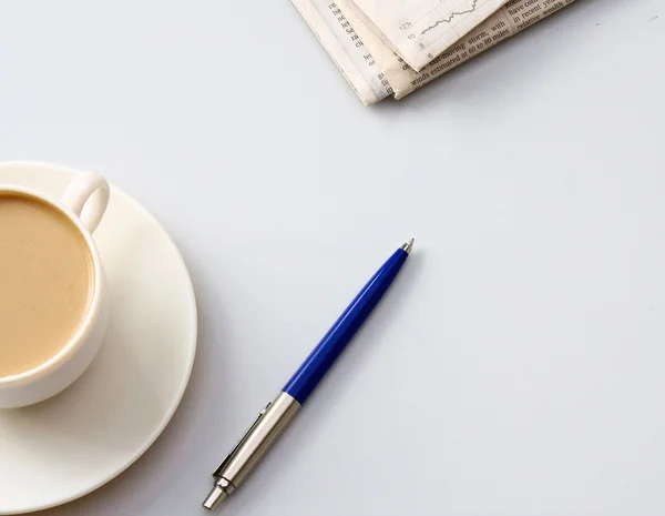 Cup of coffee near newspapers, pen — Stock Photo, Image