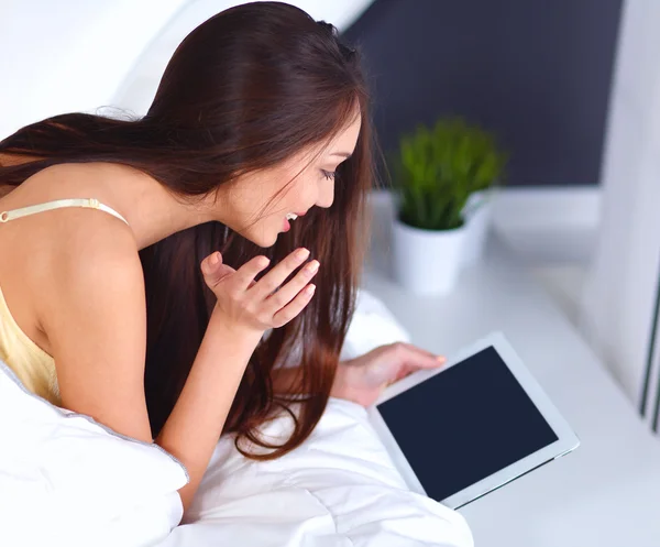 Women use a tablet pc on the bed — Stock Photo, Image