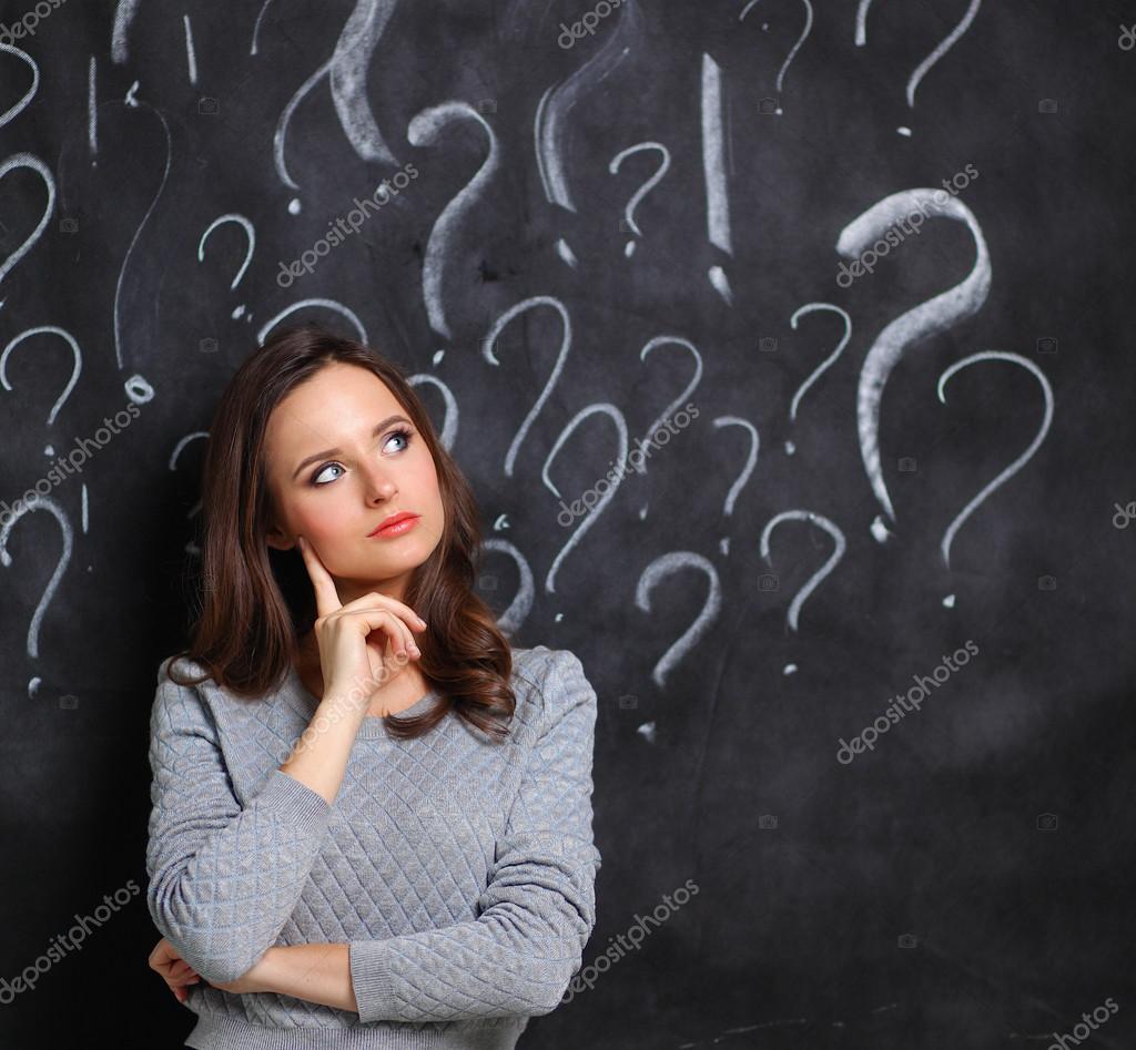 Young girl with question mark on a gray background — Stock Photo