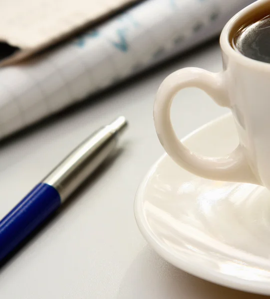 Cup of coffee near the laptop and newspapers — Stock Photo, Image