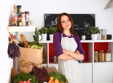 Onun mutfak masa alışveriş torbaları ile yakın duran genç kadın