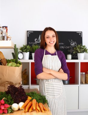 Onun mutfak masa alışveriş torbaları ile yakın duran genç kadın