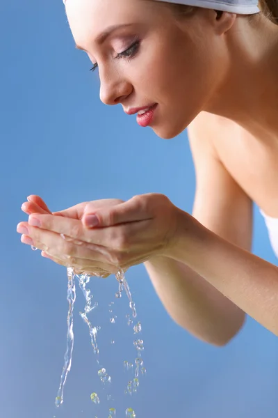 Junges Weibchen wäscht ihr Gesicht mit klarem Wasser — Stockfoto