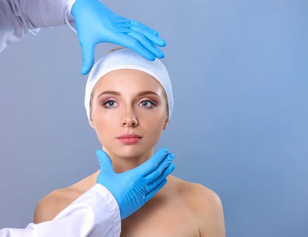 A surgeons hands touching a female face — Stock Photo, Image