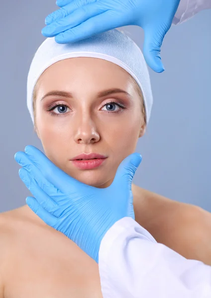 Een chirurgen handen aanraken van een vrouwelijk gezicht — Stockfoto