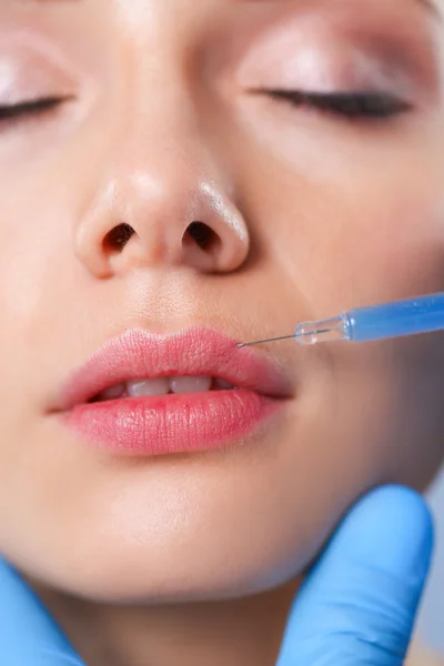 Inyección cosmética en la cara de la mujer bonita. Aislado sobre fondo gris — Foto de Stock