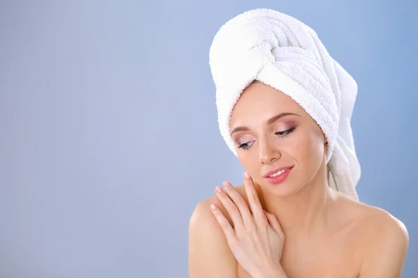 Beautiful woman with a towel on his head on a gray background — Stock Photo, Image