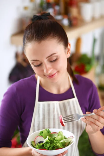 Giovane donna mangiare insalata fresca in cucina moderna — Foto Stock