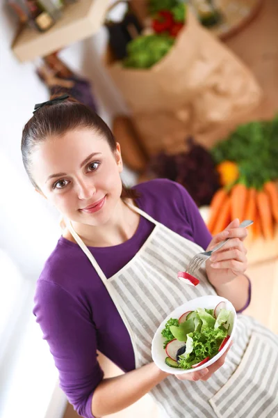 Giovane donna mangiare insalata fresca in cucina moderna — Foto Stock