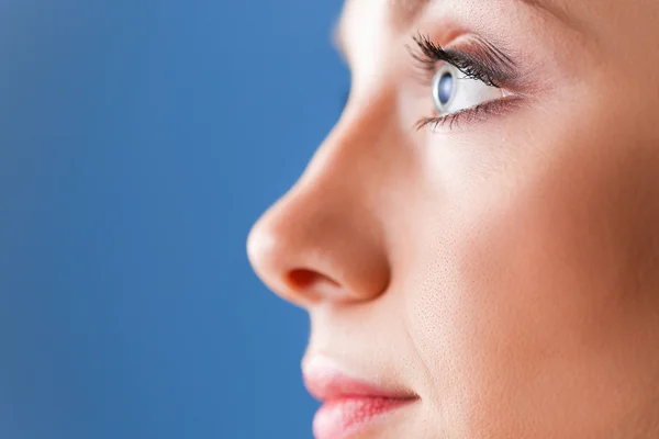 Una mujer hermosa, retrato aislado sobre fondo azul — Foto de Stock