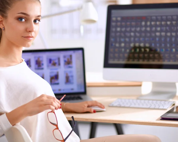 Jonge vrouw werkt in het kantoor, zit aan het bureau — Stockfoto