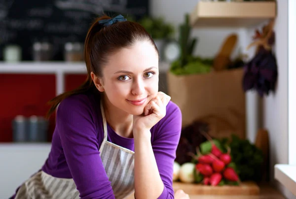 Junge Frau steht mit Einkaufstaschen in ihrer Küche neben Schreibtisch — Stockfoto