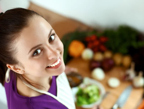 Jonge vrouw in haar keuken in de buurt van Bureau met shopping tassen — Stockfoto