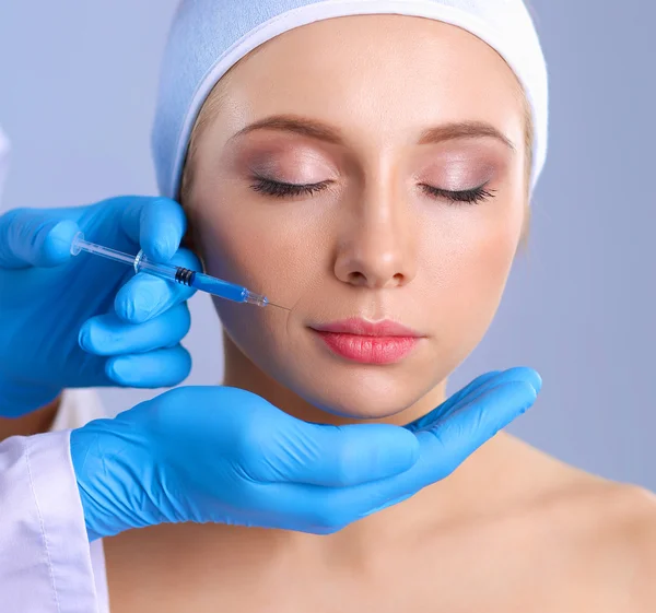 Kosmetická injekce na tváři hezká žena. Izolované na šedém pozadí — Stock fotografie