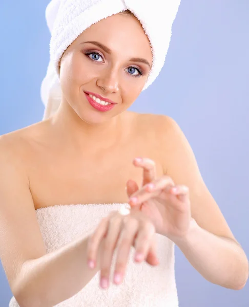 Jeune femme mettre de la crème sur sa main Isolé sur fond gris — Photo