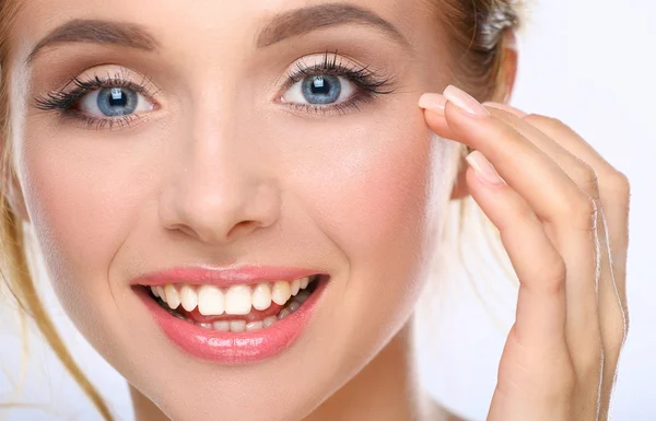 Jonge vrouw aanraken haar gezicht geïsoleerd op witte achtergrond — Stockfoto