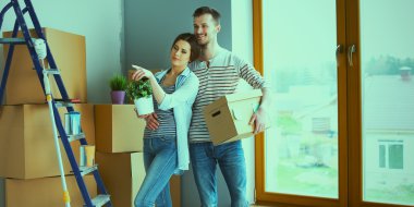 Mutlu genç çift açma veya kutu ambalaj ve yeni evine taşıdıktan