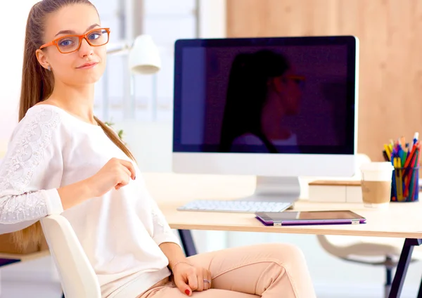 Jonge vrouw werkt in het kantoor, zit aan het bureau — Stockfoto