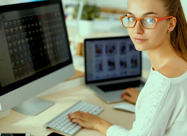 Jonge vrouw werkt in het kantoor, zit aan het bureau — Stockfoto