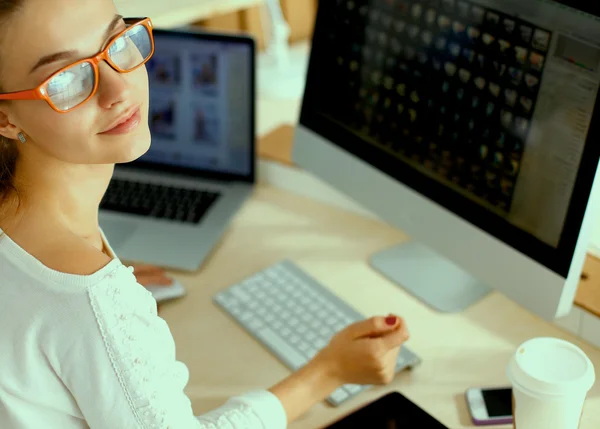 Mujer joven trabajando en la oficina, sentada en el escritorio — Foto de Stock