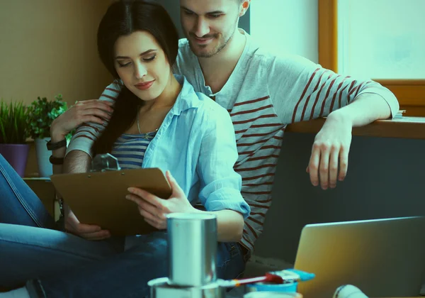 Jong koppel zittend op de vloer van hun nieuwe appartement — Stockfoto