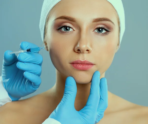 Inyección cosmética en la cara de la mujer bonita. Aislado sobre fondo gris — Foto de Stock