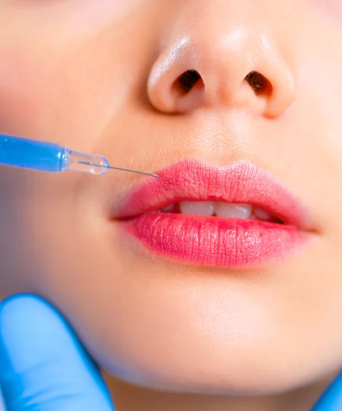 Inyección cosmética en la cara de la mujer bonita. Aislado sobre fondo gris — Foto de Stock