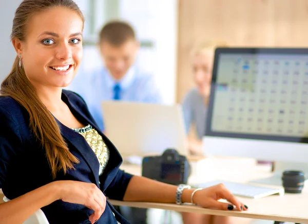 Jonge vrouw werkt in het kantoor, zit aan het bureau — Stockfoto