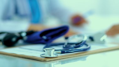 Hastanede masasında oturan genç bir kadın doktorun portresi.