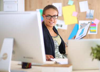 Moda tasarımcıları stüdyoda çalışıyor. Masanın üzerinde oturuyorlar.