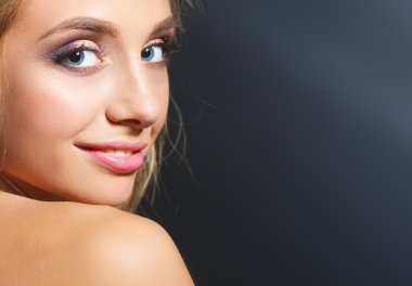 Koyu arka plan üzerinde kıvırcık uzun saçlı güzel kadın