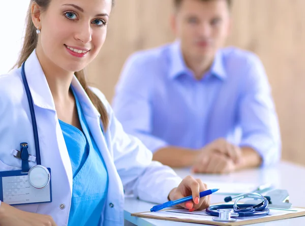 Médecin femme assise avec un patient masculin au bureau — Photo