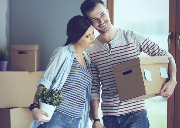 Gelukkige jonge paar uitpakken of dozen inpakken en verhuizen naar een nieuw huis — Stockfoto