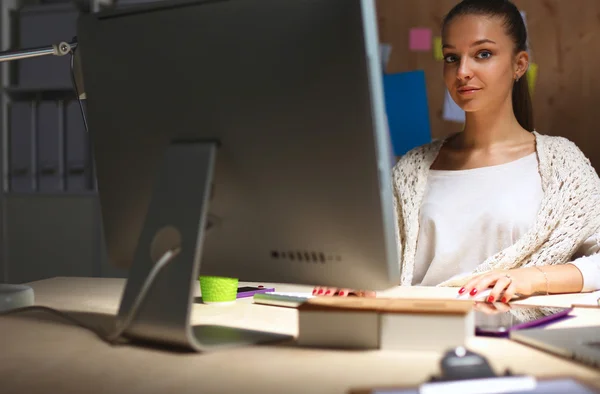 Jonge vrouw werkt in het kantoor, zit aan het bureau — Stockfoto