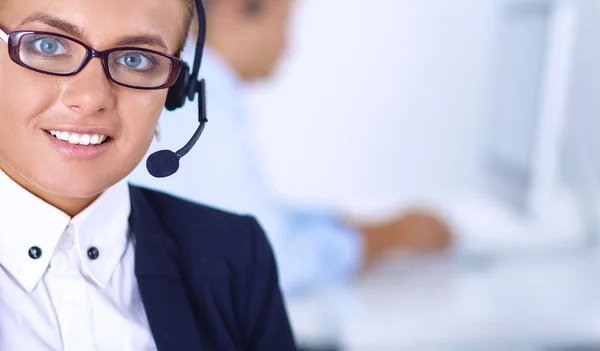 Gelukkig vrouwtje draagt een headset en zit op het bureau — Stockfoto