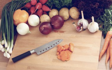 Mutfakta sebze doğrayan genç bir kadın.